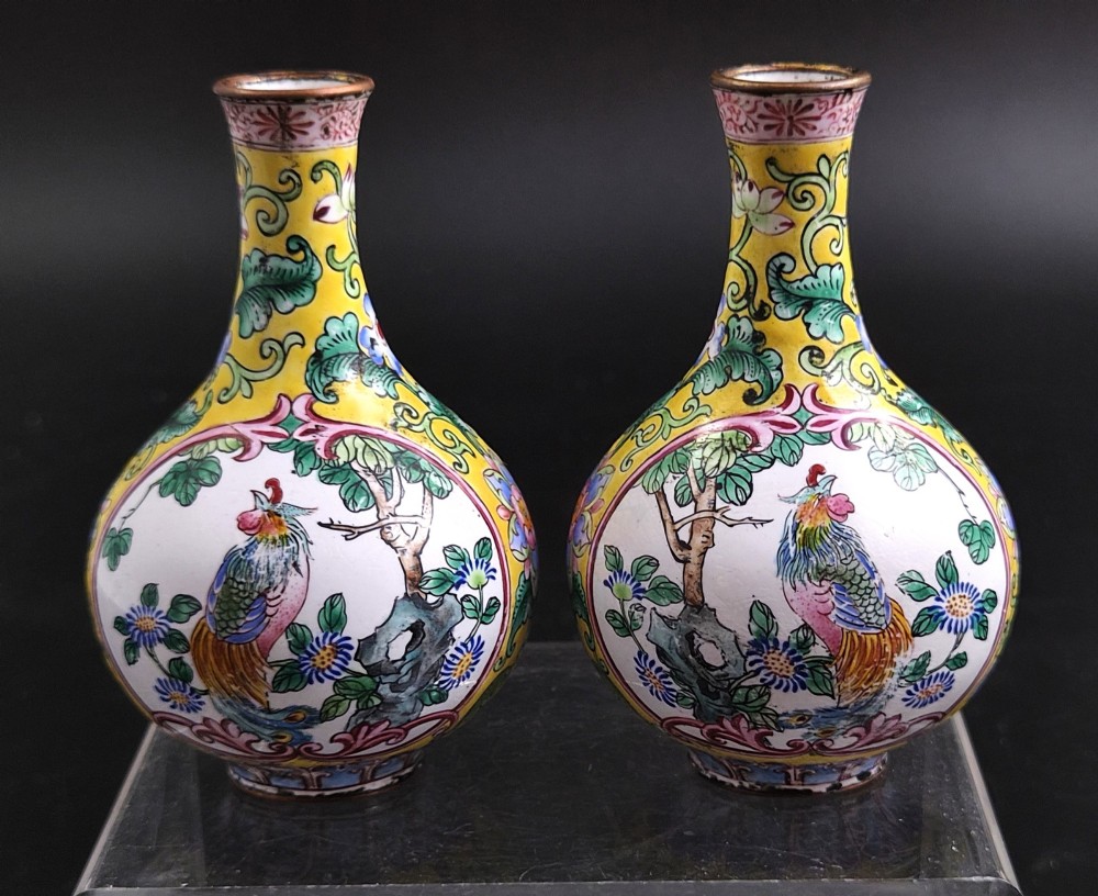 A pair of 19th-century Chinese Canton enamel miniature vases featuring hand-painted roosters and foliage framed within circular medallions against a bright yellow ground.
