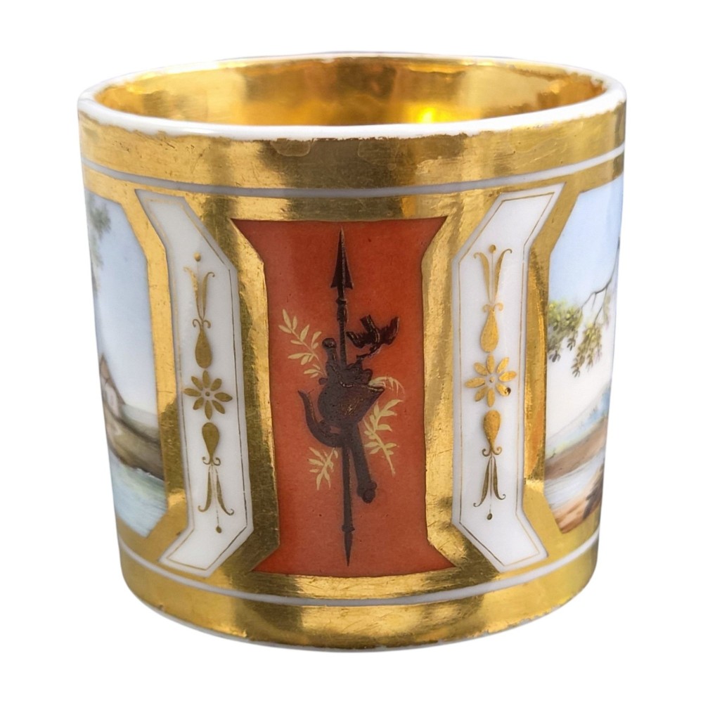 A French Old Paris porcelain cup and saucer featuring gilded trim, interior gold wash, and hand-painted panels depicting rural figures. View V
