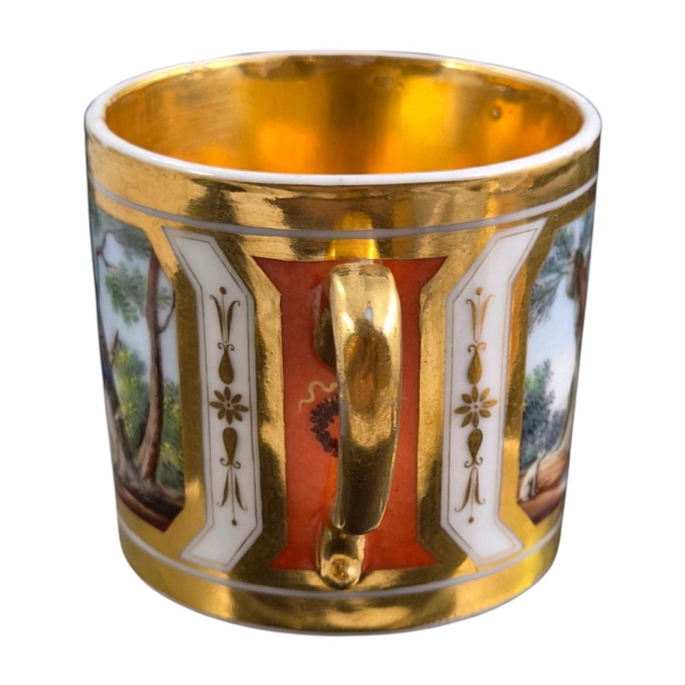 A French Old Paris porcelain cup and saucer featuring gilded trim, interior gold wash, and hand-painted panels depicting rural figures. View VII