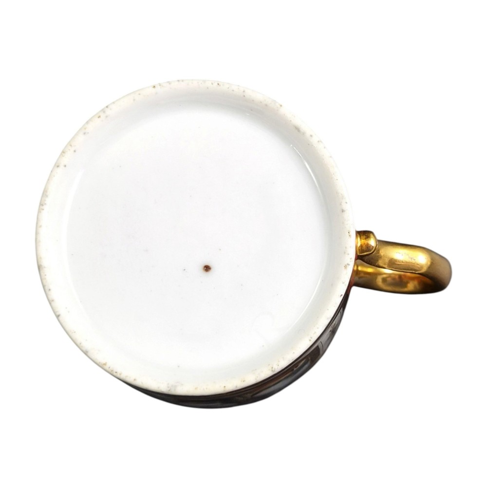 A French Old Paris porcelain cup and saucer featuring gilded trim, interior gold wash, and hand-painted panels depicting rural figures. View IX