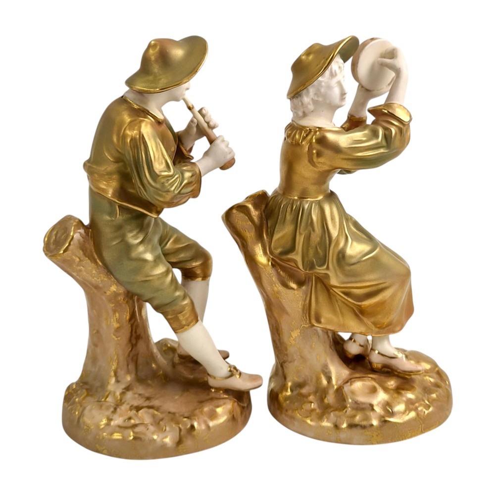 A pair of mid-century Royal Worcester bone china figurines depicting Strephon playing a pipe instrument and Phyllis playing a tambourine, finished in metallic gold and off-white porcelain. View IV