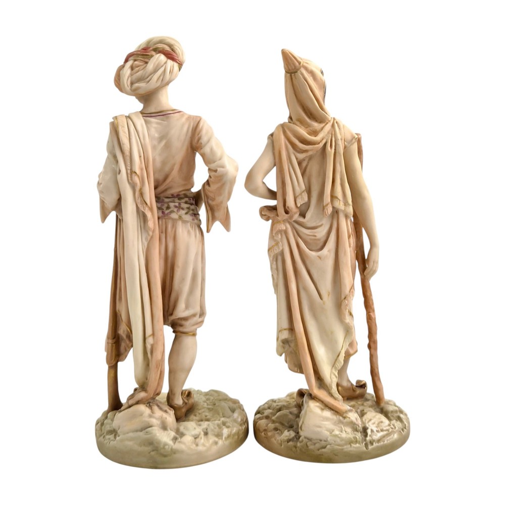 A pair of late Victorian Royal Worcester blush ivory porcelain figures depicting an Indian man and woman in detailed traditional attire with gilded accents. View III