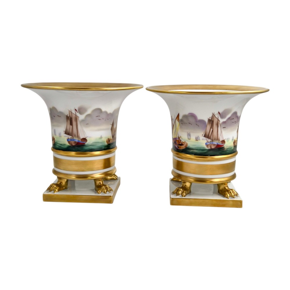 A pair of flared white porcelain Empire-style vases decorated with hand-painted sailing ships and supported by gilded paw feet. View II