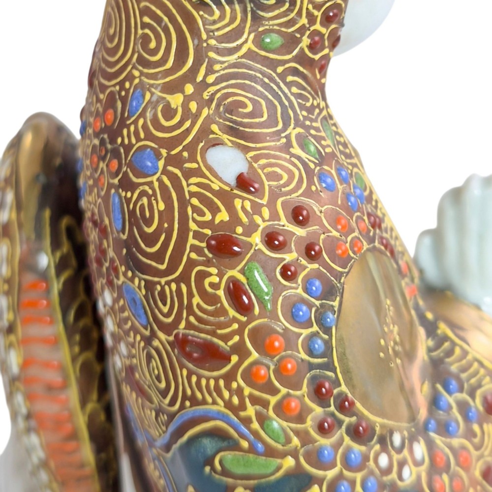 A Japanese Kutani porcelain figure of the deity Kannon in detailed patterned robes, standing atop a white sea dragon amidst sculpted waves. View XI