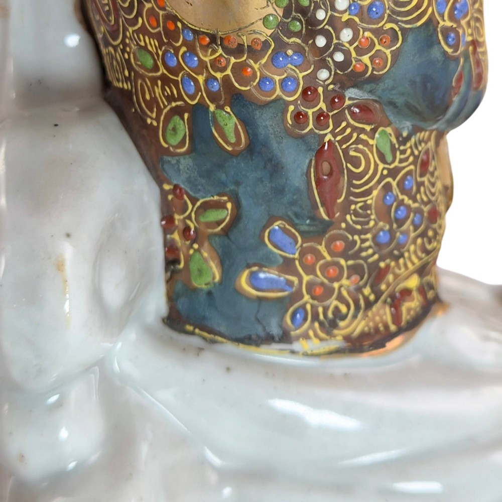 A Japanese Kutani porcelain figure of the deity Kannon in detailed patterned robes, standing atop a white sea dragon amidst sculpted waves. View XII