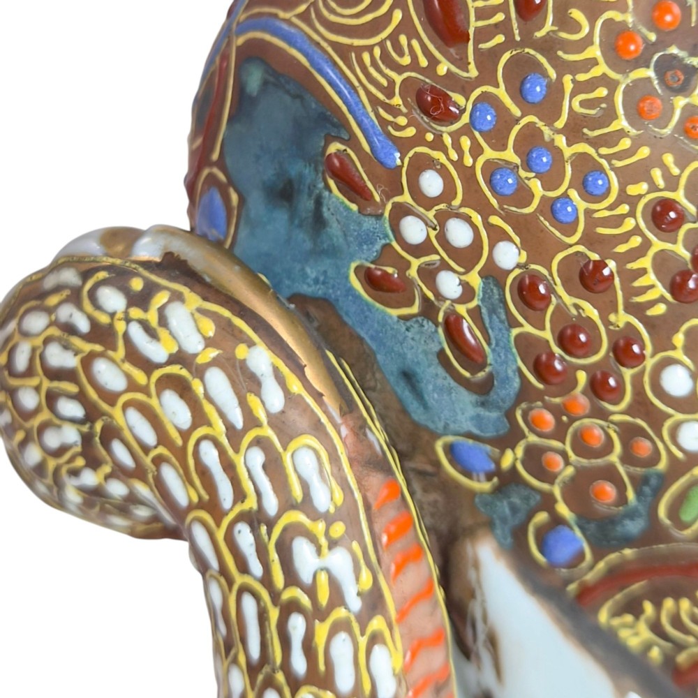 A Japanese Kutani porcelain figure of the deity Kannon in detailed patterned robes, standing atop a white sea dragon amidst sculpted waves. View XIII