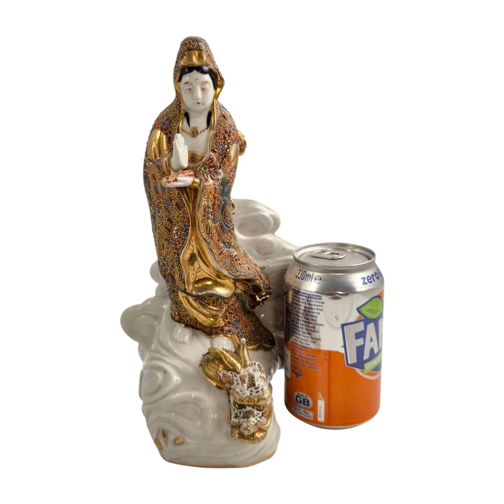 A Japanese Kutani porcelain figure of the deity Kannon in detailed patterned robes, standing atop a white sea dragon amidst sculpted waves. View XIV