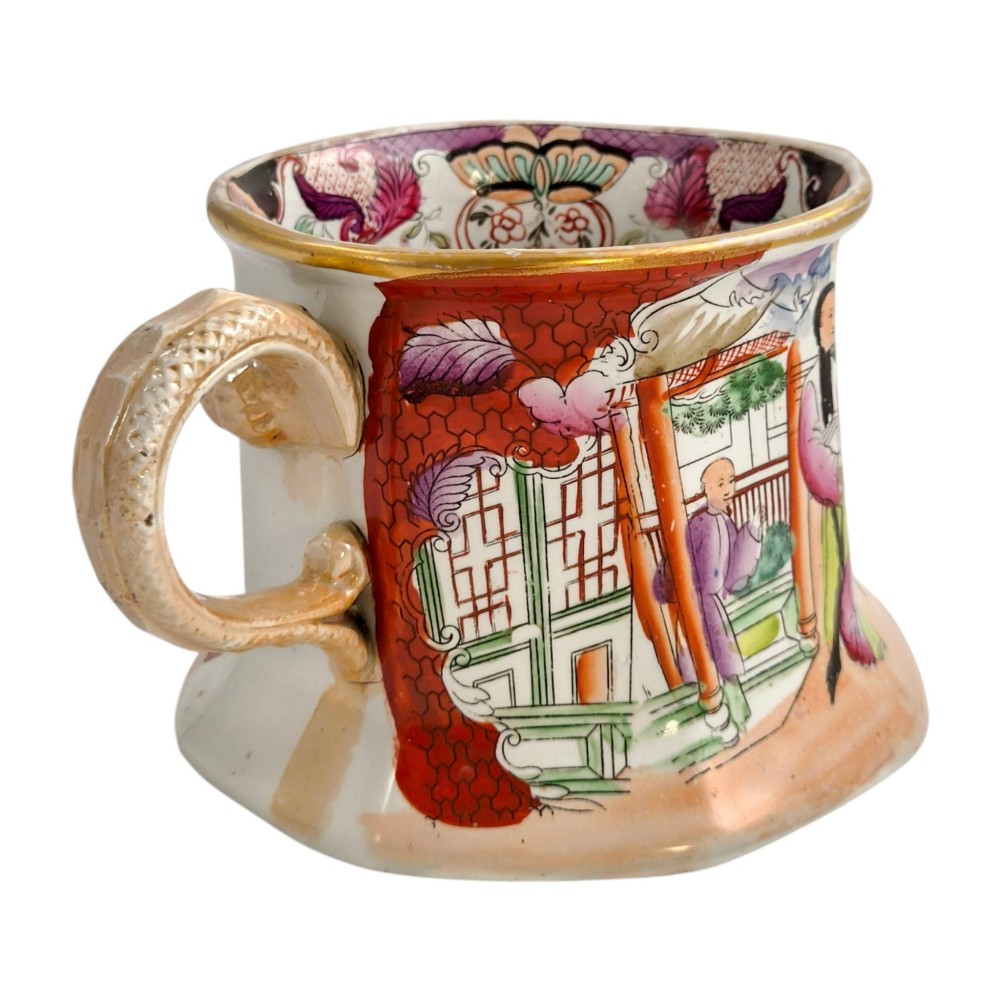 An antique Masons ironstone cider mug featuring a red scale background, hand-painted Chinoiserie panels, a flared base, and a sculpted hydra handle. View IV