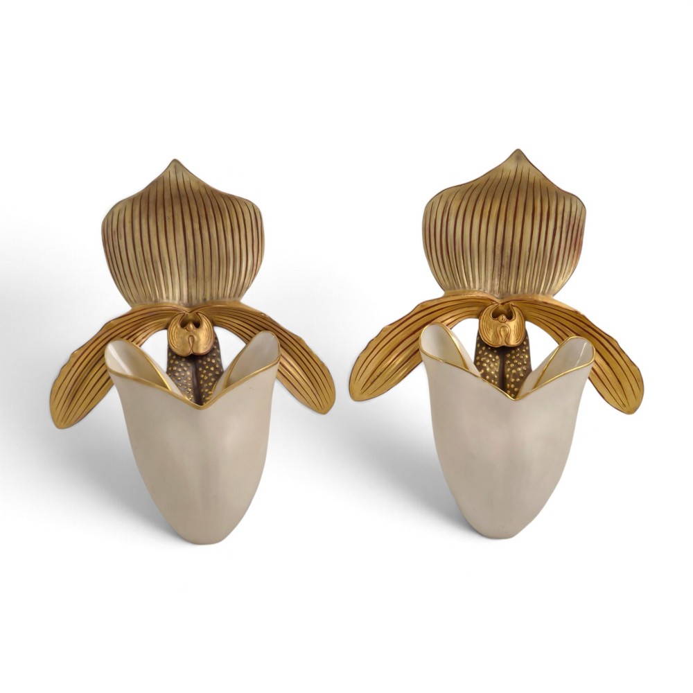 A pair of 1886 Royal Worcester ivory porcelain wall pockets shaped like ladys slipper orchids with gold gilded highlights.