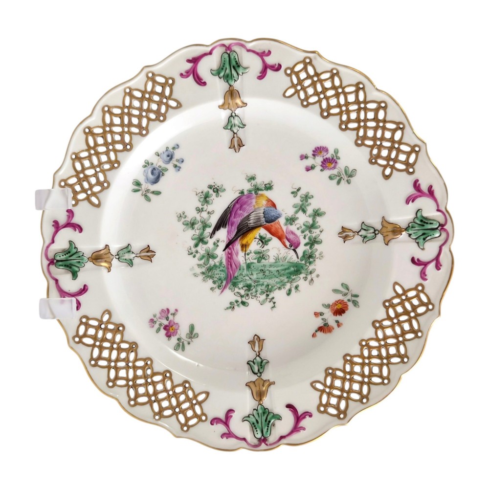 Set of three white porcelain cabinet plates featuring pierced lattice rims decorated with gold gilding, pink scrolls, green accents, and hand-painted exotic birds in the centre. View VI