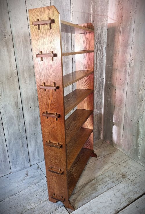fig 1. A tall open-backed oak shelving unit featuring seven horizontal tiers and visible side pegged joinery.