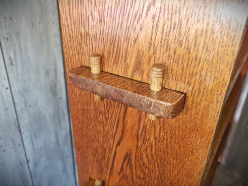 fig 2. A tall open-backed oak shelving unit featuring seven horizontal tiers and visible side pegged joinery.