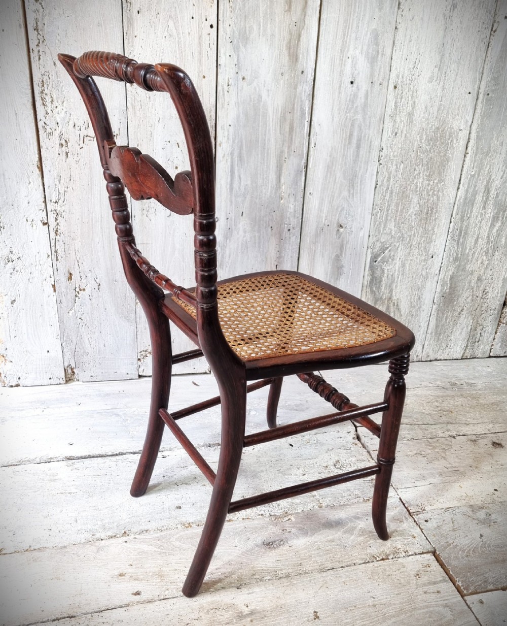 A Regency period side chair featuring a simulated rosewood finish, a rope-twist top rail, a brass-mounted centre splat, turned legs, and a hand-woven cane seat. View II