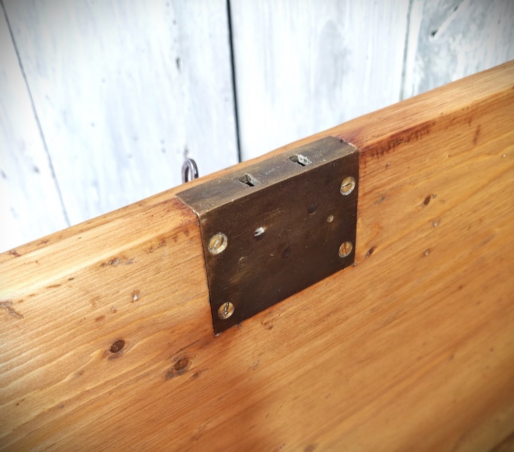 A late Victorian pine travel trunk featuring a distressed wood lid, painted sides with vintage shipping labels, central keyhole, and metal corner reinforcements. View XII