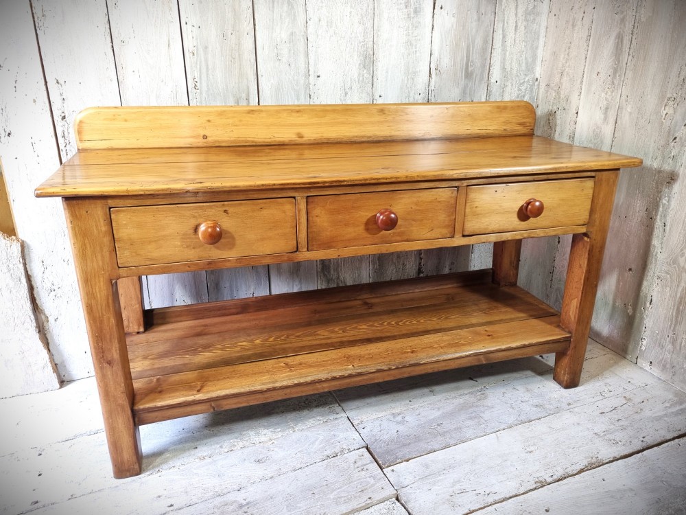 A Victorian pine dresser base featuring three upper drawers with turned wooden knobs, a simple rear upstand, and an open lower pot shelf. View III