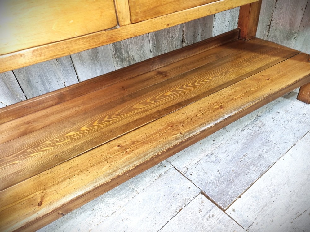 A Victorian pine dresser base featuring three upper drawers with turned wooden knobs, a simple rear upstand, and an open lower pot shelf. View V