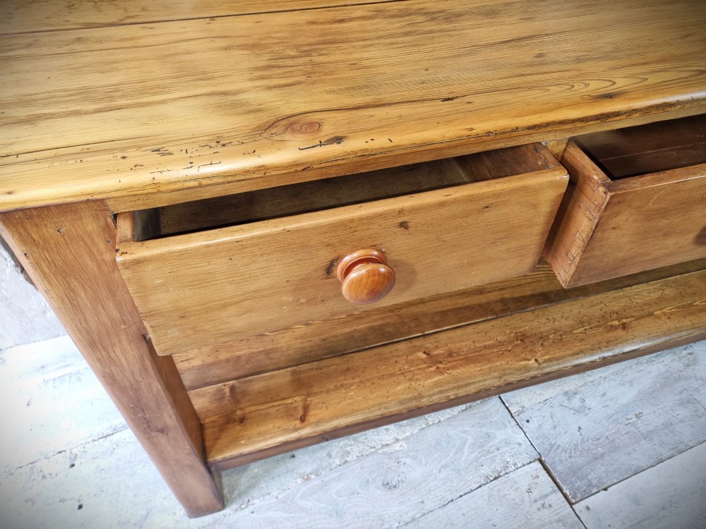 A Victorian pine dresser base featuring three upper drawers with turned wooden knobs, a simple rear upstand, and an open lower pot shelf. View VIII