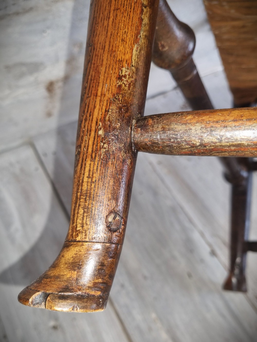 An antique Cheshire ladder back armchair featuring shaped horizontal slats, swept armrests, turned legs, and a woven rush seat. View XII