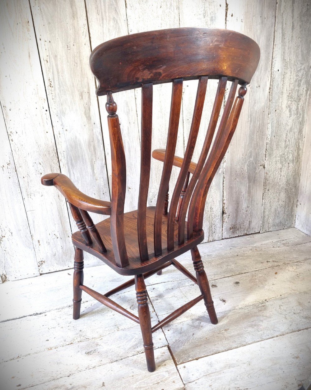 A Victorian lath back Windsor armchair crafted from warm brown polished wood with a shaped elm seat and turned beech legs. View IV