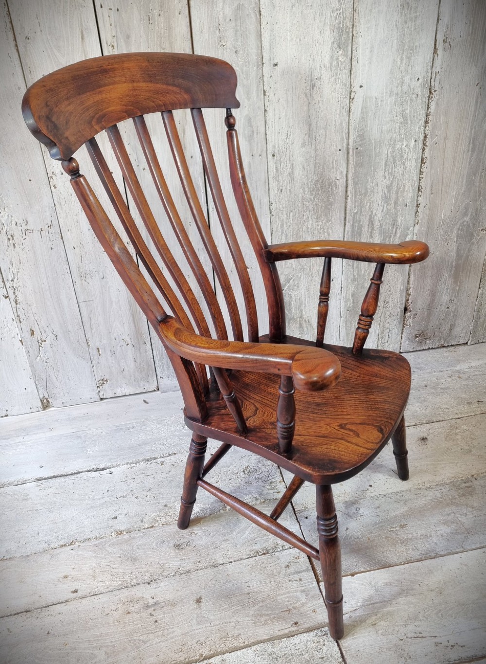 A Victorian lath back Windsor armchair crafted from warm brown polished wood with a shaped elm seat and turned beech legs. View VI
