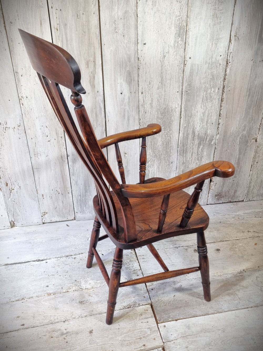 A Victorian lath back Windsor armchair crafted from warm brown polished wood with a shaped elm seat and turned beech legs. View VII