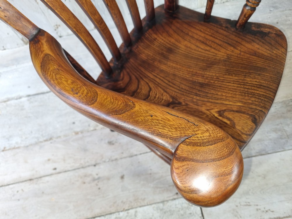 A Victorian lath back Windsor armchair crafted from warm brown polished wood with a shaped elm seat and turned beech legs. View VIII