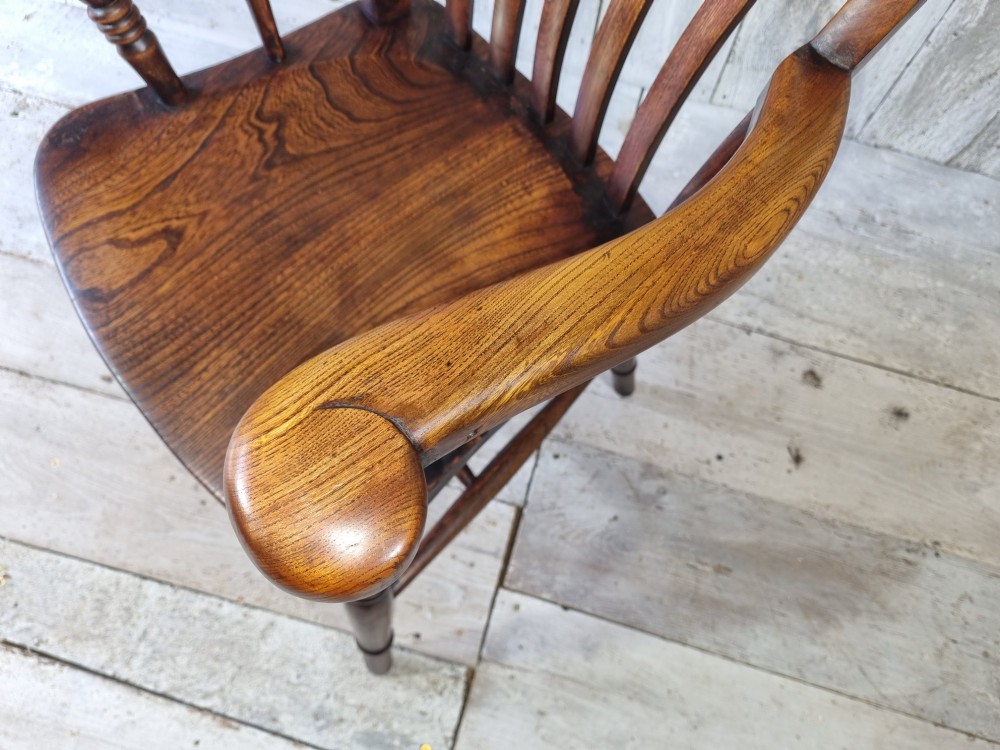 A Victorian lath back Windsor armchair crafted from warm brown polished wood with a shaped elm seat and turned beech legs. View X