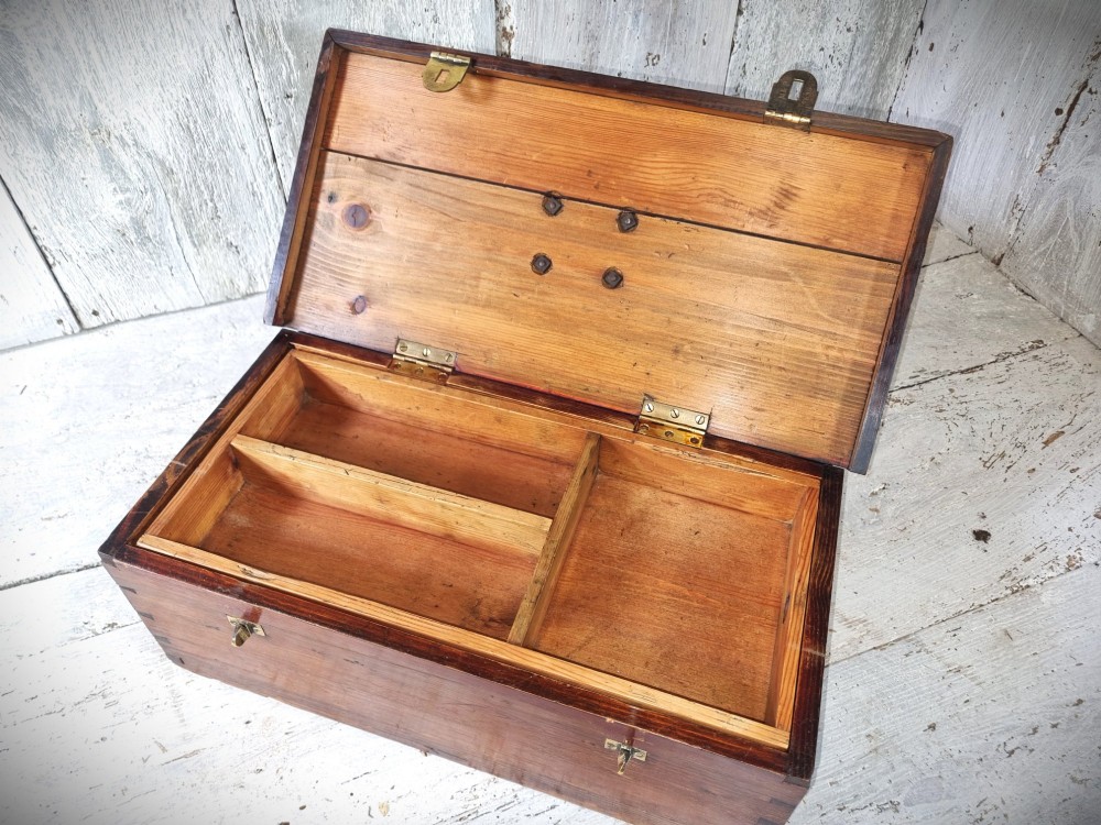A rectangular warm brown wooden tool box featuring white stencilled text, a central winged logo, and an iron top clasp. View XI