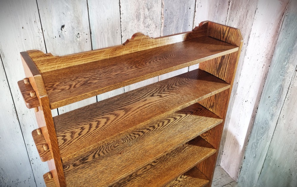 A tall open-backed oak shelving unit featuring seven horizontal tiers and visible side pegged joinery. View VII