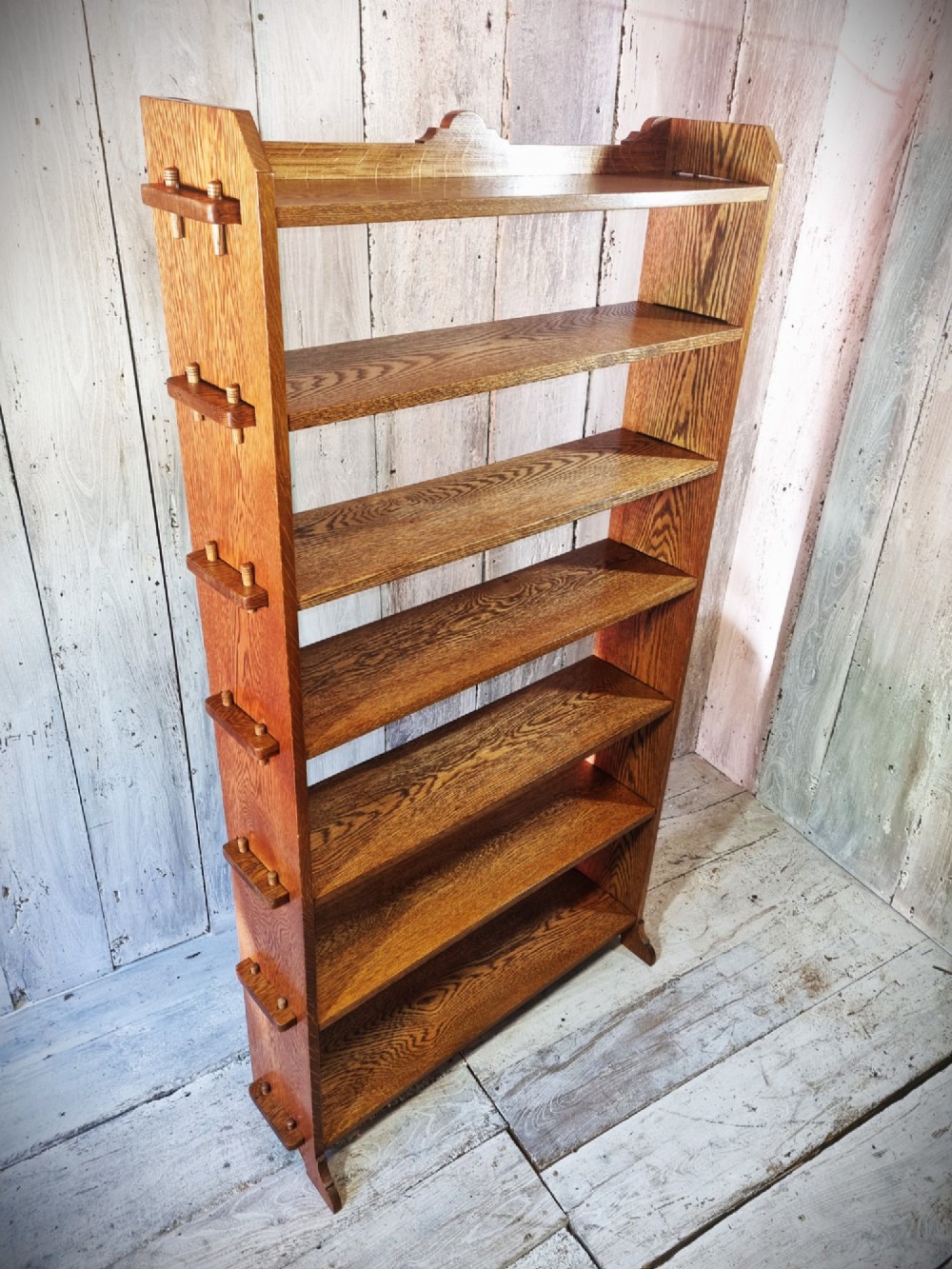 A tall open-backed oak shelving unit featuring seven horizontal tiers and visible side pegged joinery. View VIII