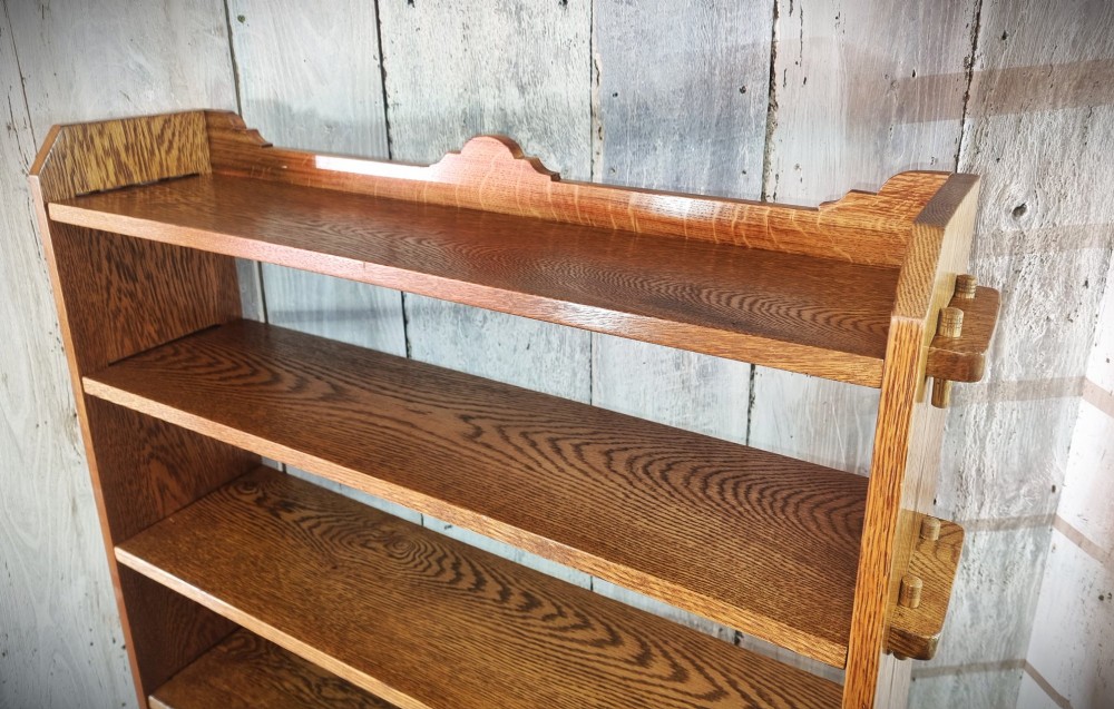 A tall open-backed oak shelving unit featuring seven horizontal tiers and visible side pegged joinery. View IX