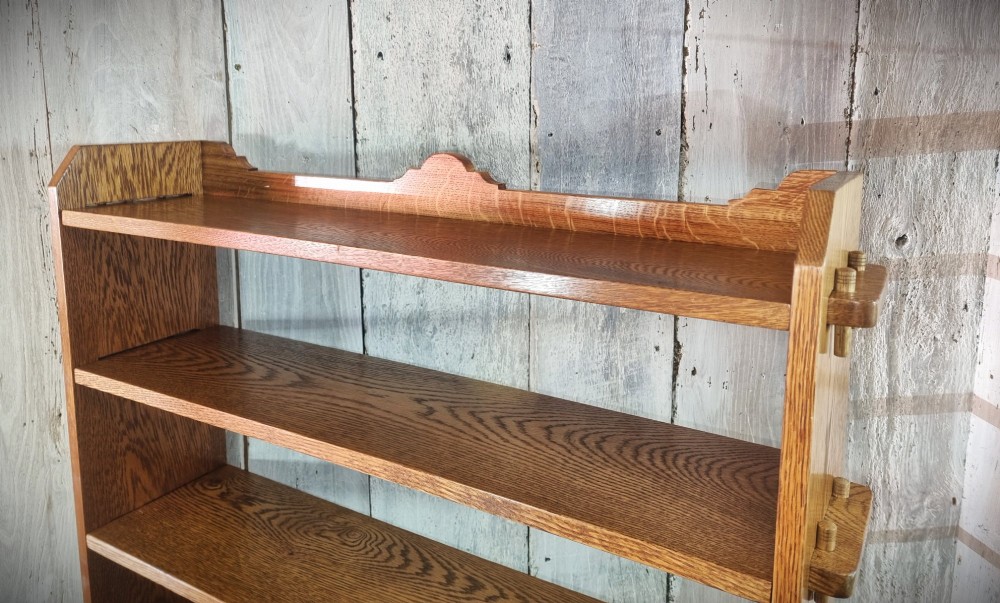 A tall open-backed oak shelving unit featuring seven horizontal tiers and visible side pegged joinery. View XII