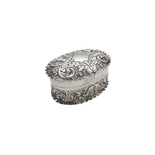 fig 1. An oval antique sterling silver trinket box featuring detailed repousse scrollwork on the lid and sides.