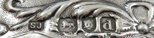 fig 1. A small late Victorian sterling silver box featuring intricate pierced scrollwork and a central embossed scene depicting a figure in historic dress.