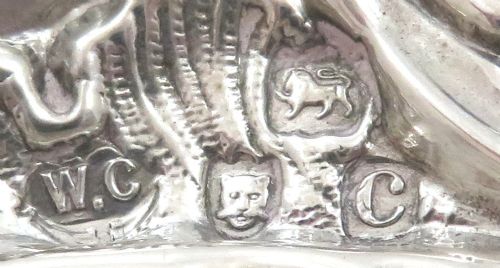 fig 1. An antique late Victorian sterling silver photo frame featuring a heart-shaped aperture and ornate repousse scrollwork with cherubs.