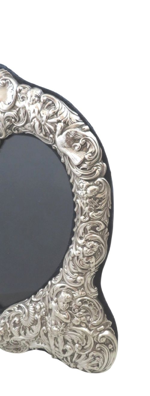 fig 2. An antique late Victorian sterling silver photo frame featuring a heart-shaped aperture and ornate repousse scrollwork with cherubs.