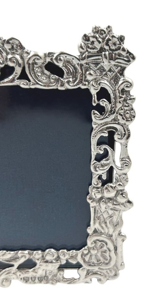 An ornate rectangular sterling silver landscape photo frame featuring detailed repousse scrollwork around the border. View III