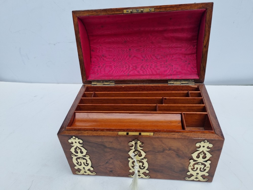 A Victorian walnut dome top stationery box featuring decorative pierced brass strapwork mounts and keyhole escutcheon. View II