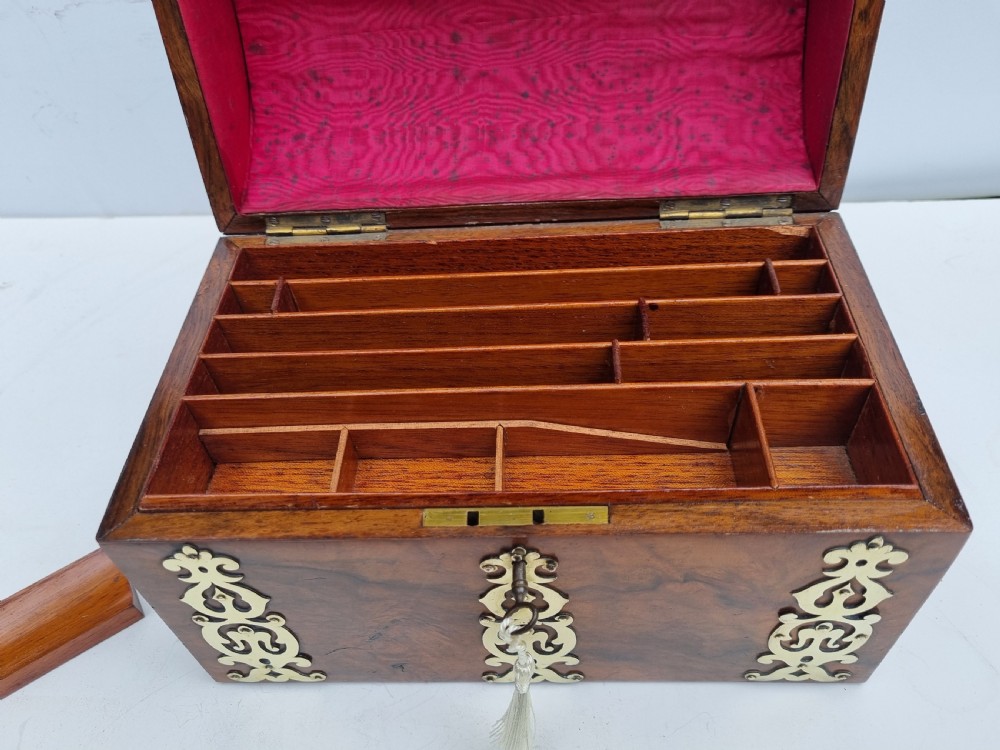 A Victorian walnut dome top stationery box featuring decorative pierced brass strapwork mounts and keyhole escutcheon. View III