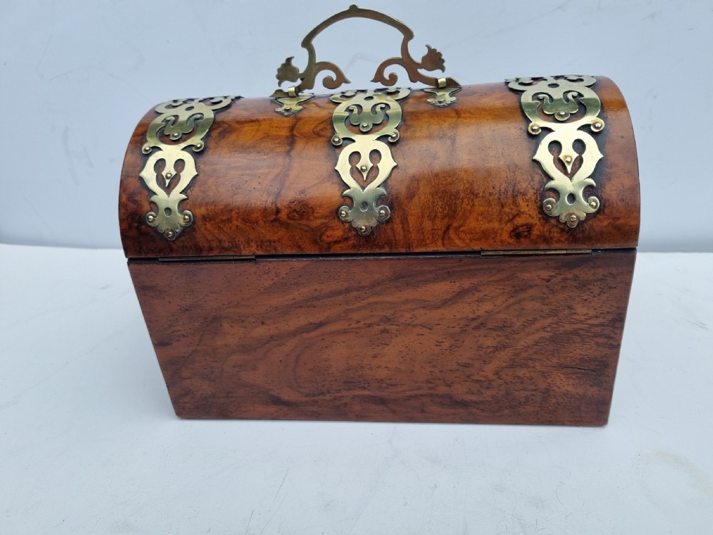 A Victorian walnut dome top stationery box featuring decorative pierced brass strapwork mounts and keyhole escutcheon. View VII