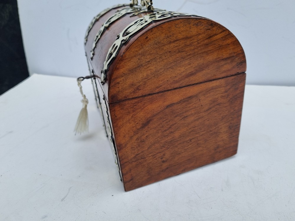A Victorian walnut dome top stationery box featuring decorative pierced brass strapwork mounts and keyhole escutcheon. View VIII