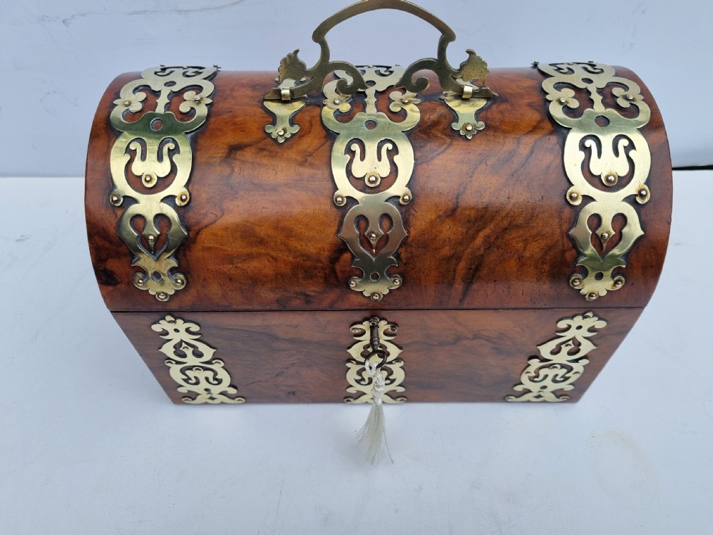 A Victorian walnut dome top stationery box featuring decorative pierced brass strapwork mounts and keyhole escutcheon. View X