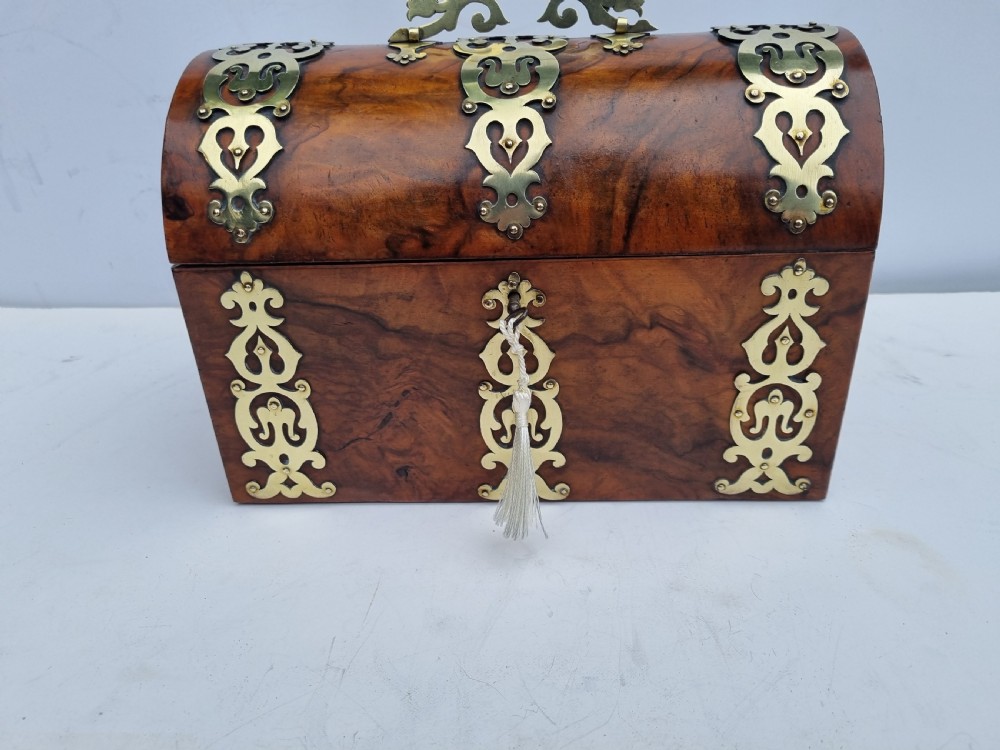 A Victorian walnut dome top stationery box featuring decorative pierced brass strapwork mounts and keyhole escutcheon. View XI