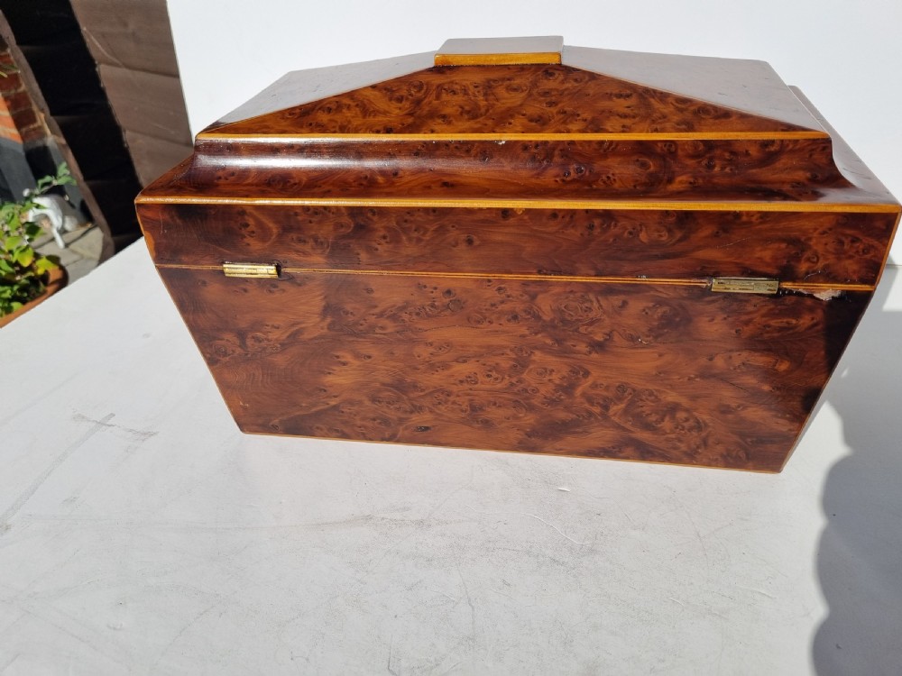 A Georgian burr yew tea caddy featuring a sarcophagus-shaped lid, boxwood stringing inlay, and a central keyhole escutcheon. View IV