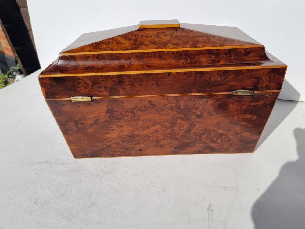 A Georgian burr yew tea caddy featuring a sarcophagus-shaped lid, boxwood stringing inlay, and a central keyhole escutcheon. View V