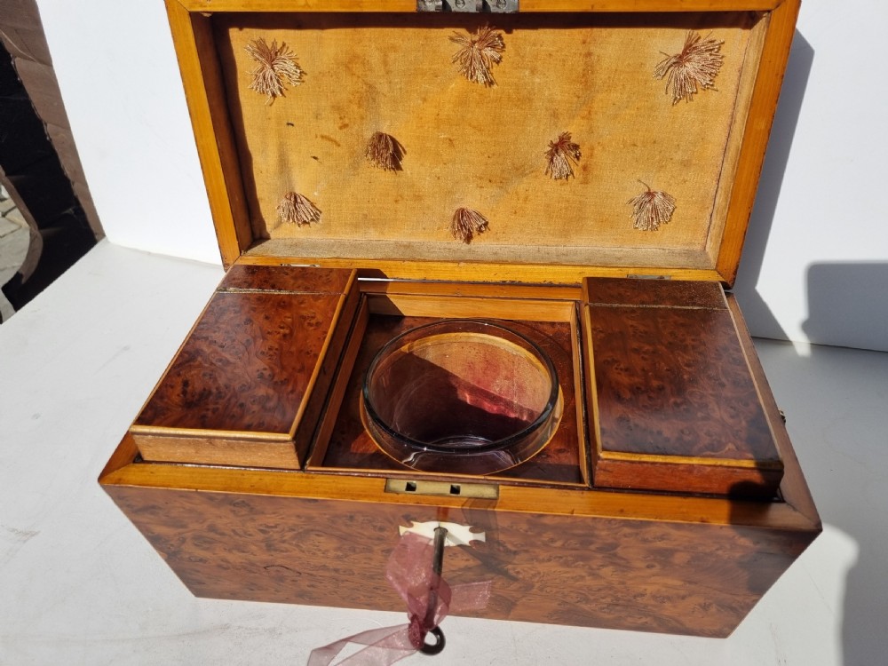 A Georgian burr yew tea caddy featuring a sarcophagus-shaped lid, boxwood stringing inlay, and a central keyhole escutcheon. View VI