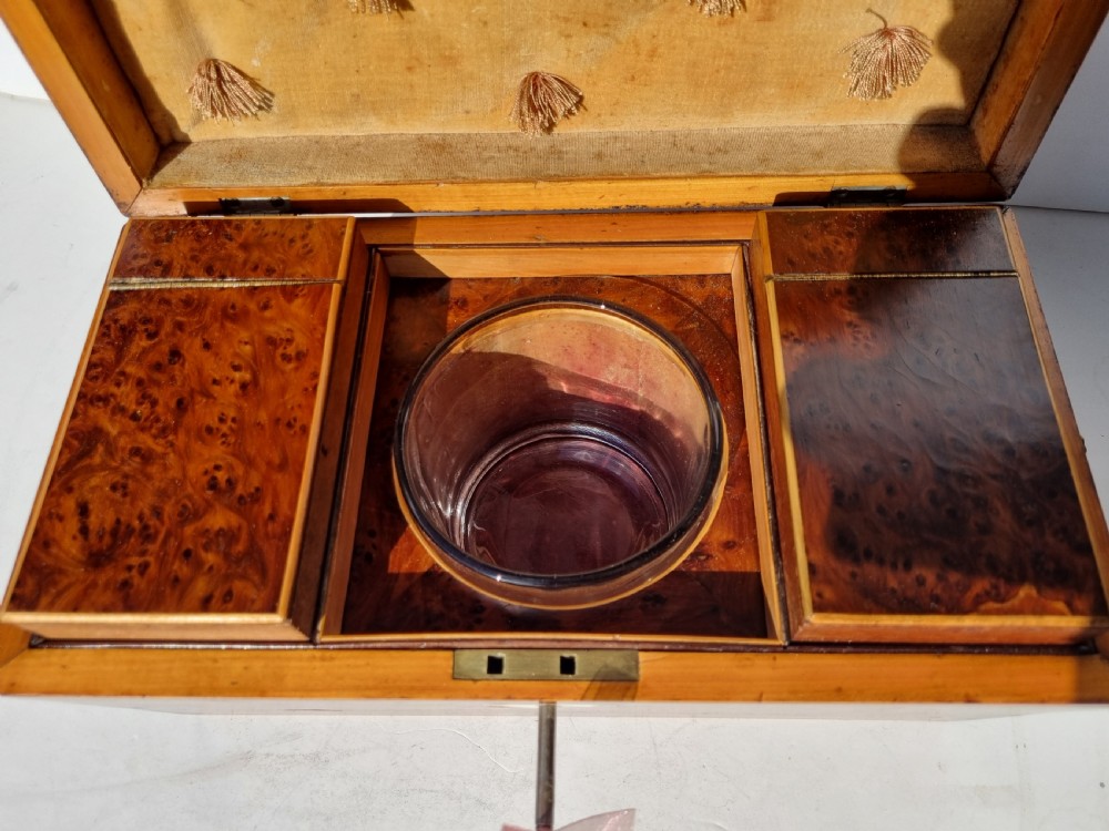 A Georgian burr yew tea caddy featuring a sarcophagus-shaped lid, boxwood stringing inlay, and a central keyhole escutcheon. View VII