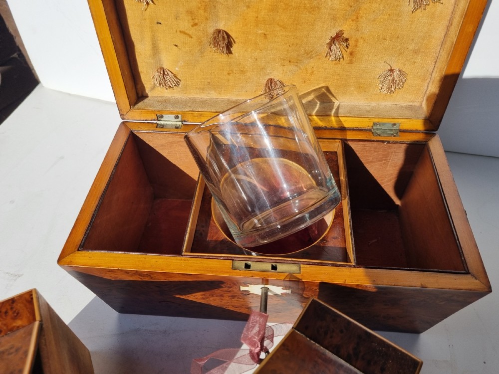A Georgian burr yew tea caddy featuring a sarcophagus-shaped lid, boxwood stringing inlay, and a central keyhole escutcheon. View IX