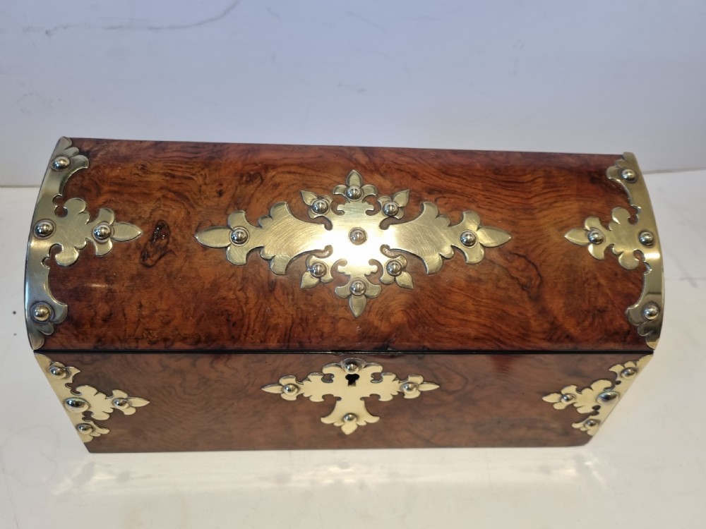 A Victorian burr walnut stationery box with a dome lid, ornamented with pierced brass mounts and a decorative brass keyhole escutcheon. View II
