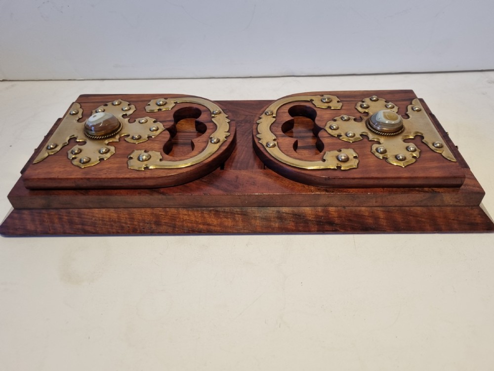 A Victorian walnut expanding book slide featuring hinged arched ends ornamented with pierced brass gothic strapwork and inset agate cabochons.
